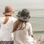 two women at beach, from back